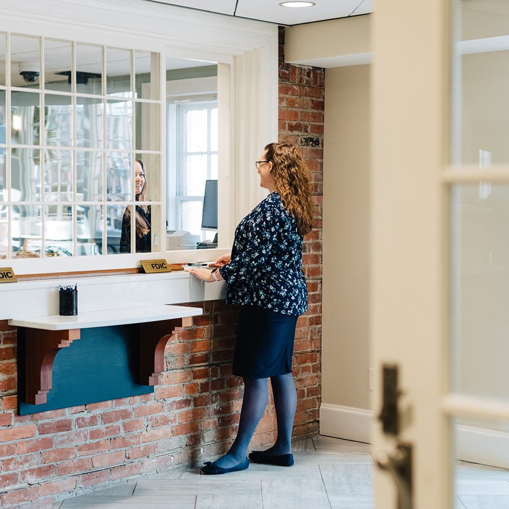 A woman talking to a bank teller